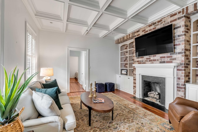 living area with wood finished floors, a fireplace, coffered ceiling, and beam ceiling