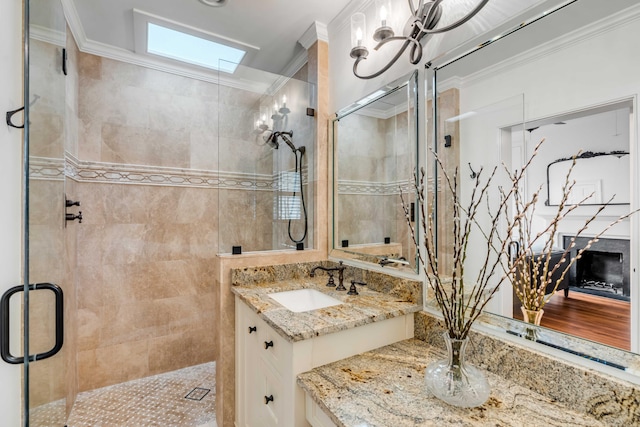 bathroom with a stall shower, a skylight, vanity, and crown molding