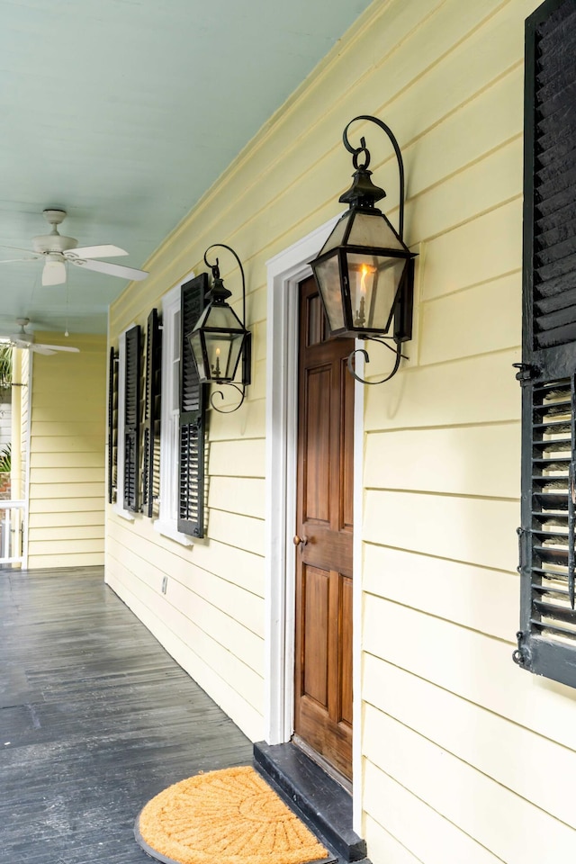 doorway to property with a porch and a ceiling fan