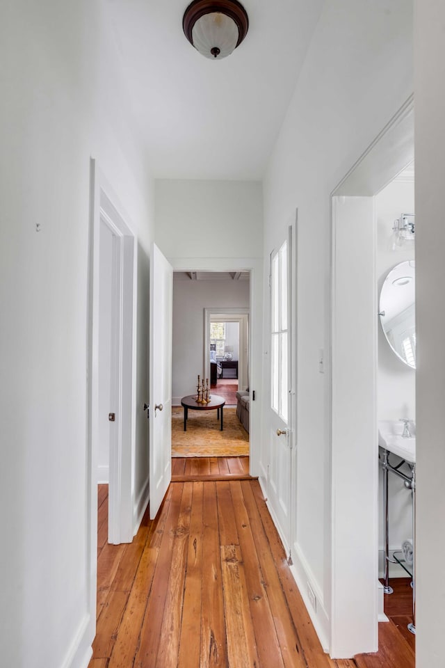 hallway with light wood-style flooring and baseboards