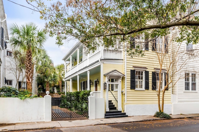 view of front of home with a fenced front yard and a balcony