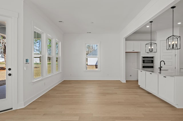 71 Downing Dr, Beaufort, SC 29907 - kitchen with white cabinetry, a chandelier, light wood-style floors, baseboards, and crown molding