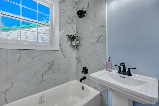 bathroom featuring tiled shower / bath and sink