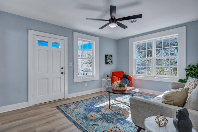 living area featuring hardwood / wood-style floors and ceiling fan