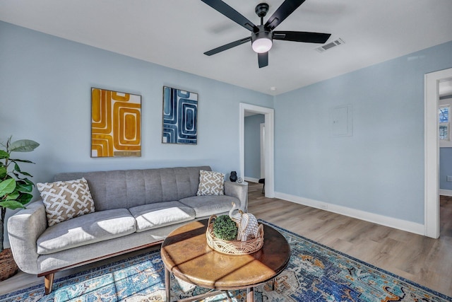 living room featuring wood-type flooring and ceiling fan