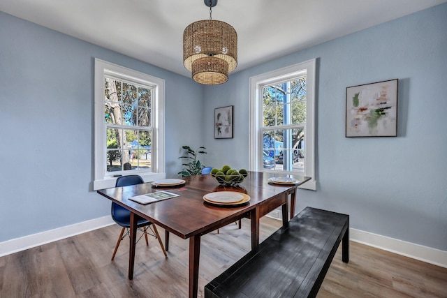 dining space with hardwood / wood-style flooring and an inviting chandelier