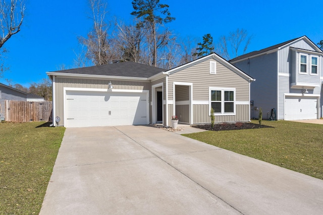 view of front of house with driveway, a front yard, an attached garage, and fence