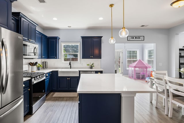 8402 Loggers Run, North Charleston, SC 29420 - kitchen with stainless steel appliances, blue cabinetry, a sink, light wood-style flooring, and recessed lighting