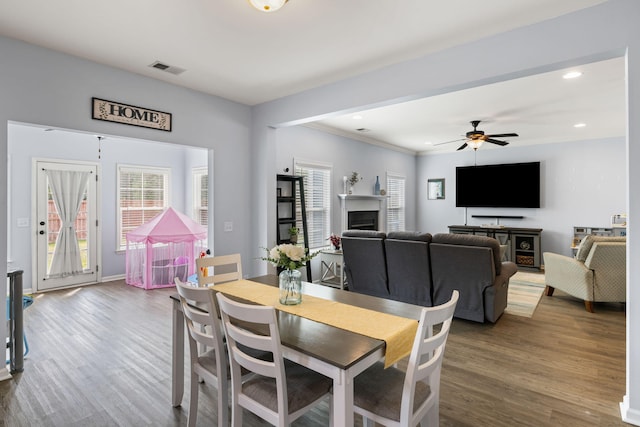 8402 Loggers Run, North Charleston, SC 29420 - dining space with a fireplace, wood finished floors, a ceiling fan, crown molding, and recessed lighting