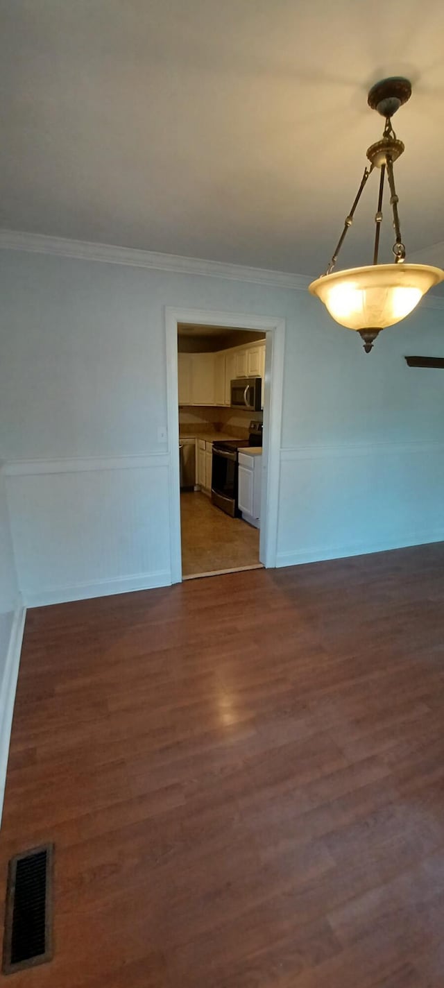 empty room with dark hardwood / wood-style flooring and ornamental molding