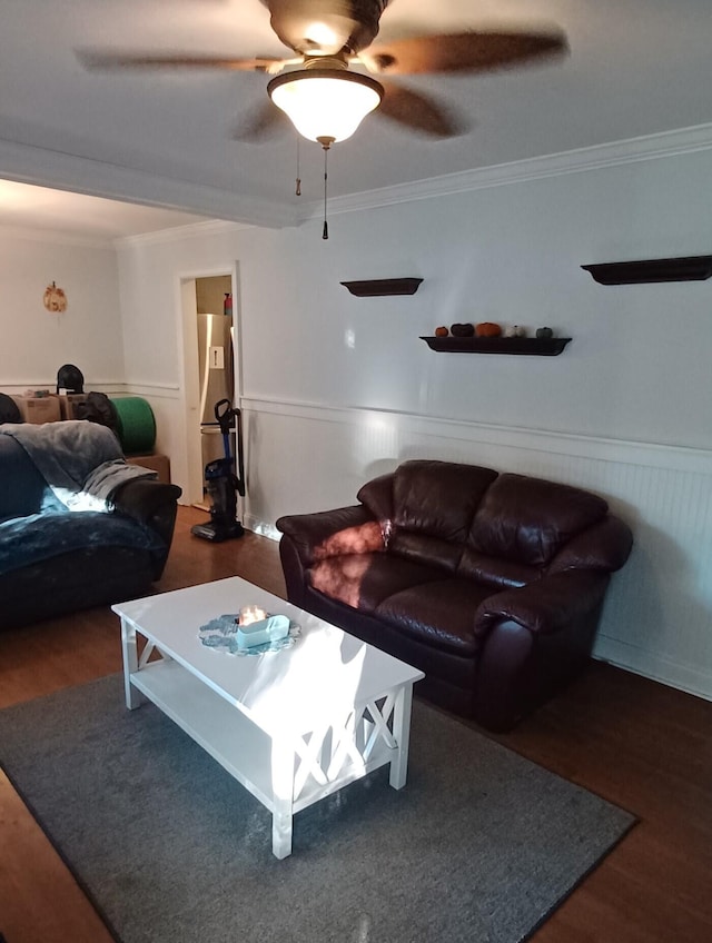 living room with ceiling fan, ornamental molding, and dark wood-type flooring