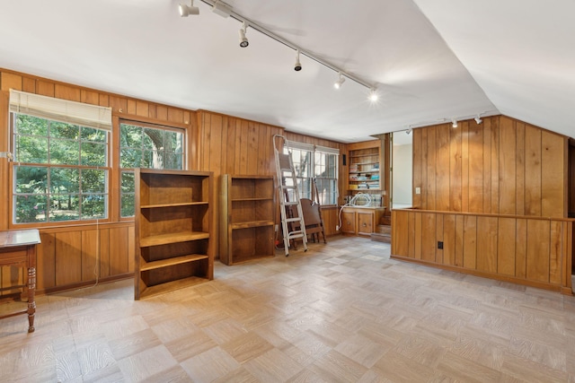 bonus room with a wealth of natural light, wooden walls, and lofted ceiling