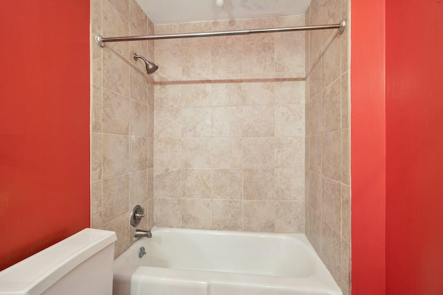 bathroom with tiled shower / bath combo and toilet