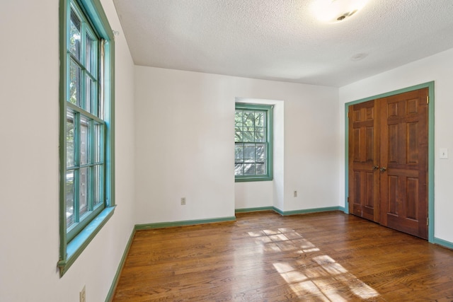 spare room with dark hardwood / wood-style flooring and a textured ceiling