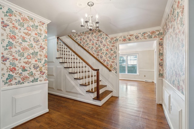 stairway featuring crown molding, a notable chandelier, and hardwood / wood-style flooring