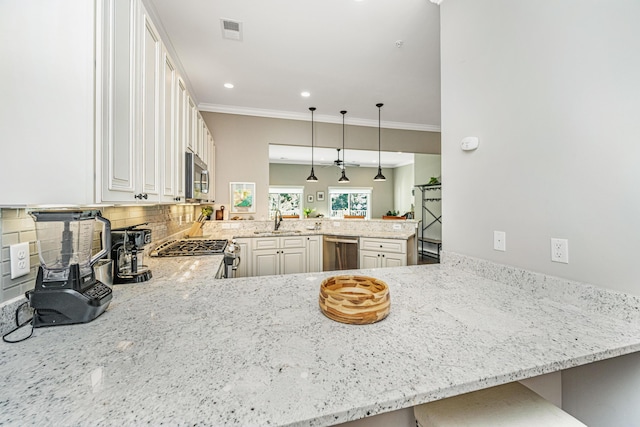 kitchen featuring visible vents, a sink, appliances with stainless steel finishes, a peninsula, and decorative backsplash