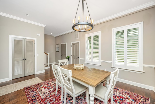 dining area featuring crown molding, visible vents, a chandelier, baseboards, and hardwood / wood-style flooring