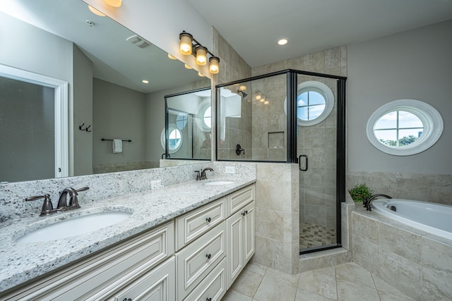 bathroom with a bath, a sink, a shower stall, double vanity, and tile patterned flooring