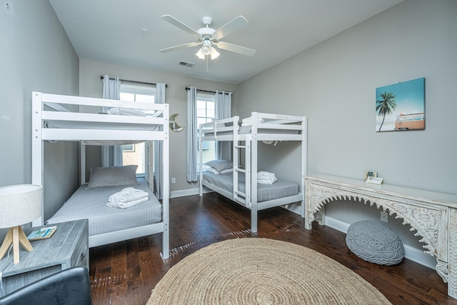 bedroom featuring ceiling fan, visible vents, wood finished floors, lofted ceiling, and baseboards