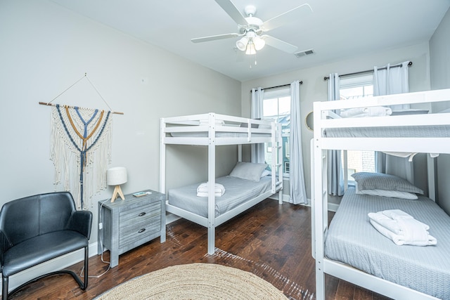 bedroom with wood finished floors, baseboards, a ceiling fan, and visible vents