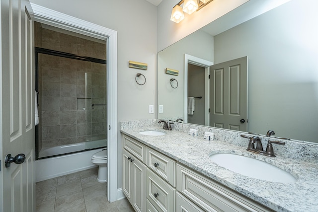 full bath featuring double vanity, a sink, toilet, and enclosed tub / shower combo