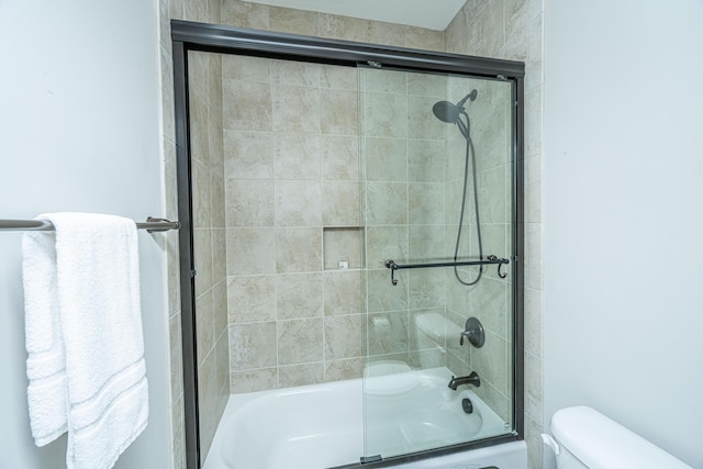 full bath with toilet and shower / bath combination with glass door