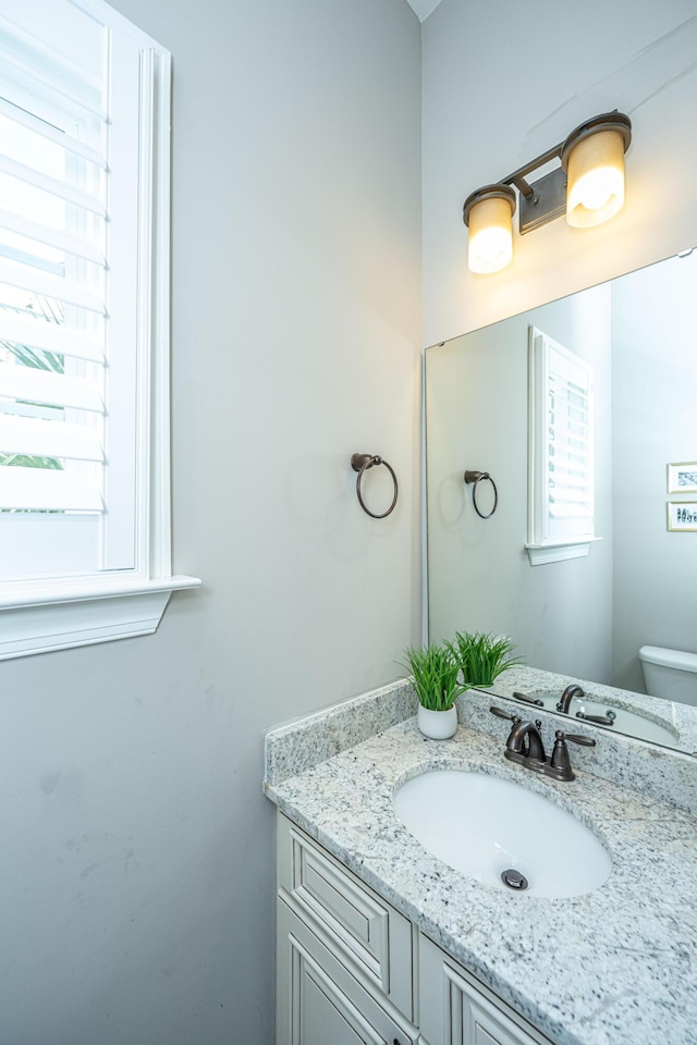 half bath featuring toilet and vanity
