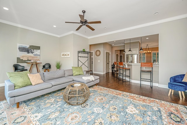 living area featuring dark wood-style flooring, baseboards, a ceiling fan, and crown molding