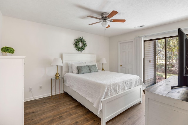 bedroom featuring dark hardwood / wood-style flooring, access to outside, a textured ceiling, and ceiling fan