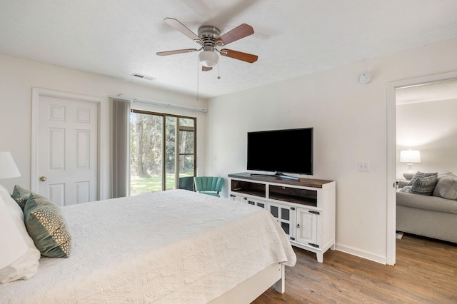 bedroom with dark hardwood / wood-style floors, access to exterior, and ceiling fan