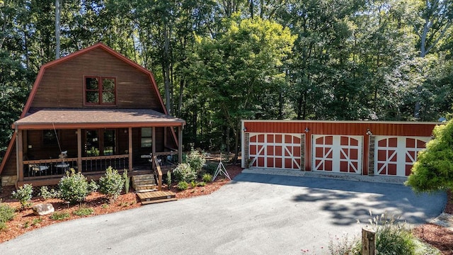 view of front of house featuring a porch and an outdoor structure