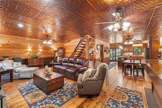 living room with light wood-type flooring and wood walls