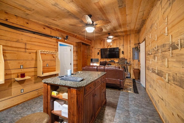 kitchen with wood walls, a center island, ceiling fan, and wood ceiling