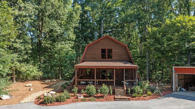 view of front of house featuring a porch, a garage, and an outdoor structure