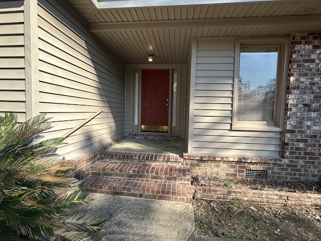 doorway to property featuring crawl space and brick siding