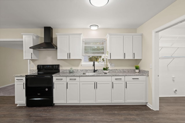 kitchen with black electric range oven, wall chimney range hood, a sink, white cabinetry, and dark wood-style flooring