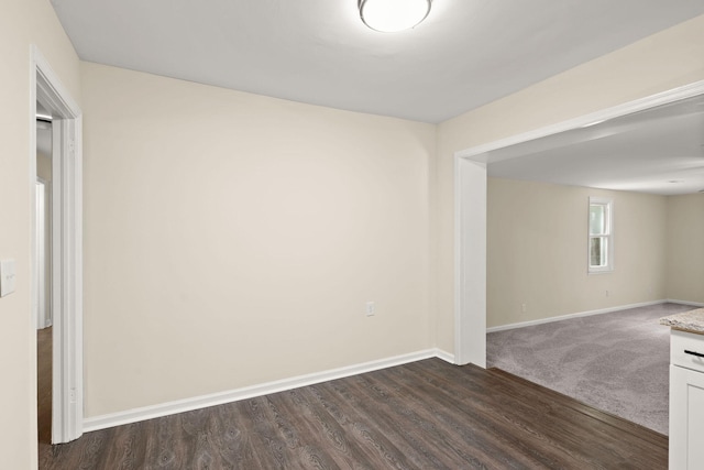 empty room with baseboards and dark wood finished floors