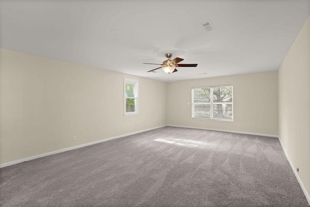 unfurnished room with carpet floors, a ceiling fan, and baseboards