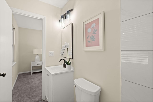bathroom featuring vanity, toilet, and baseboards
