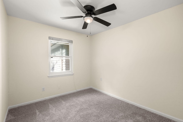 carpeted spare room featuring baseboards and ceiling fan
