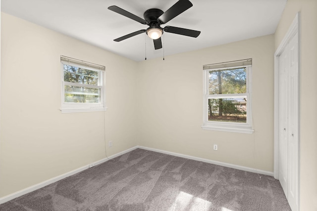 unfurnished bedroom featuring carpet floors, baseboards, a closet, and ceiling fan