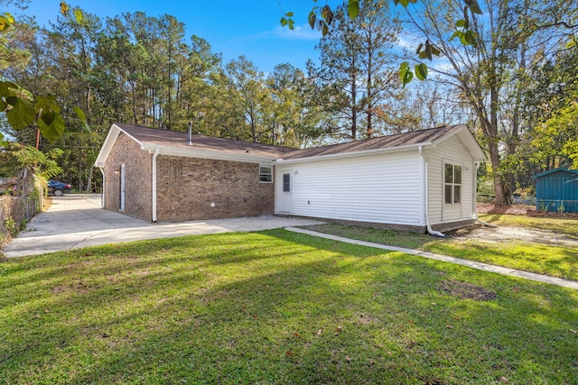 back of property with a patio, a yard, and brick siding