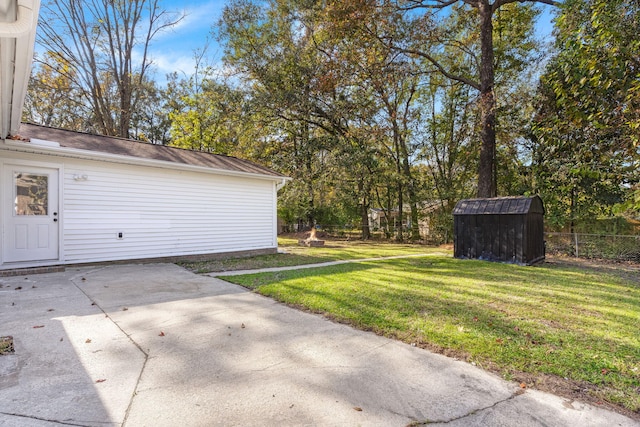 view of yard featuring a patio area, a storage unit, and an outbuilding