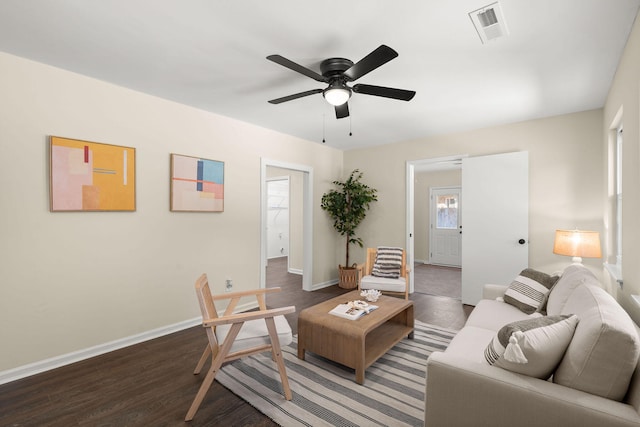 living area featuring wood finished floors, baseboards, and a ceiling fan