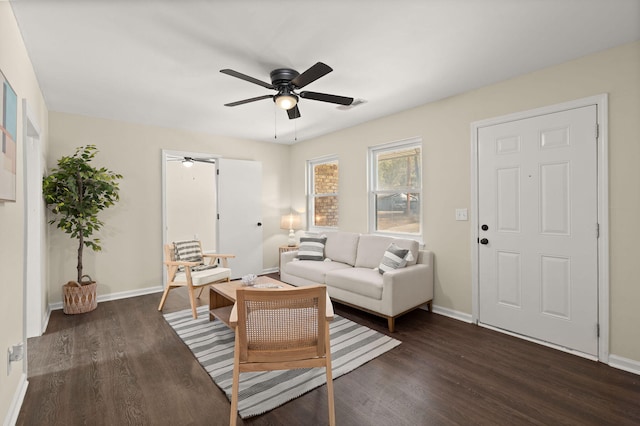 living area featuring ceiling fan, dark wood-type flooring, and baseboards