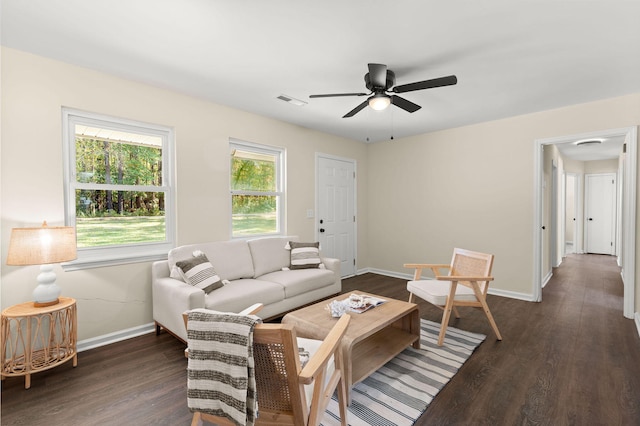 living room featuring baseboards, ceiling fan, and dark wood finished floors