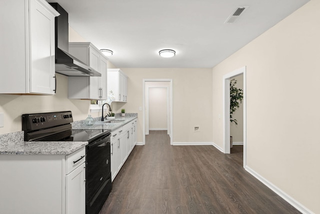 kitchen featuring electric range, wall chimney exhaust hood, dark wood-type flooring, a sink, and baseboards
