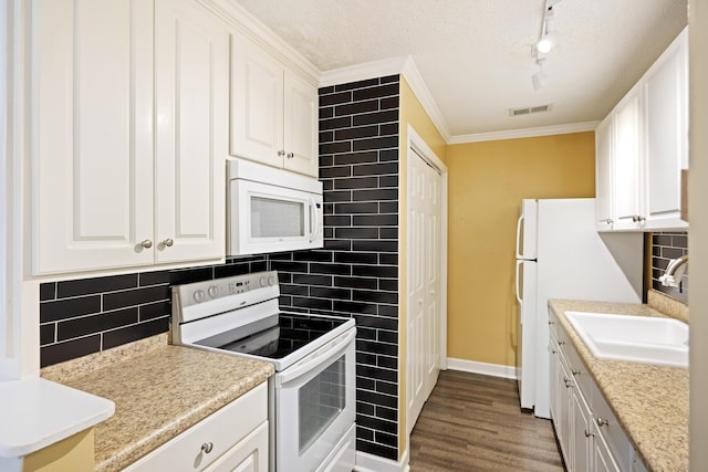 kitchen featuring white appliances, sink, ornamental molding, dark hardwood / wood-style flooring, and white cabinetry