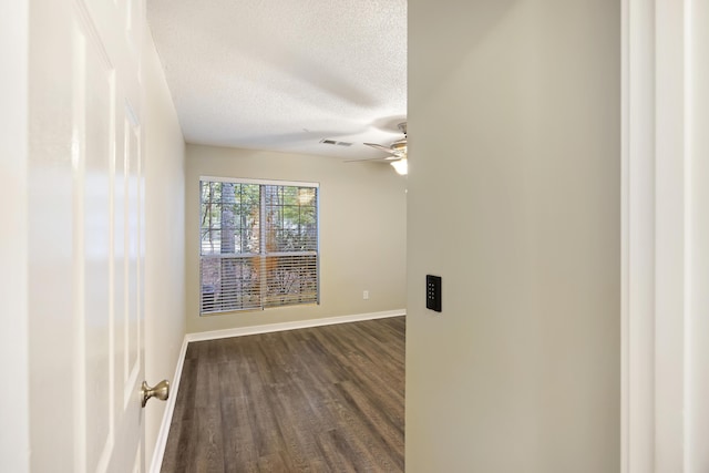 unfurnished room featuring a textured ceiling, dark hardwood / wood-style flooring, and ceiling fan