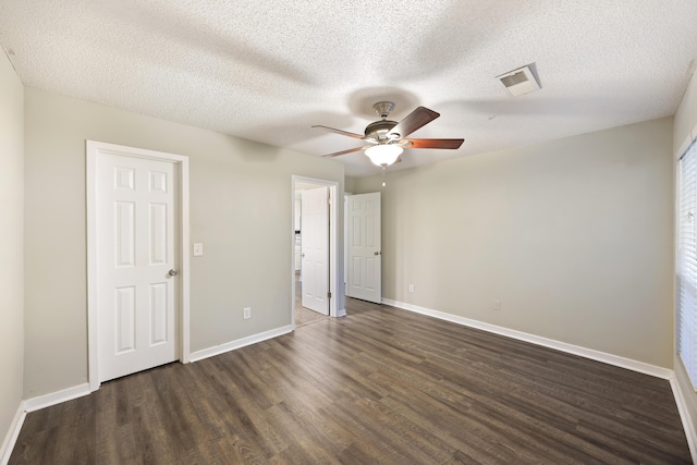 unfurnished bedroom featuring a textured ceiling, ceiling fan, and dark wood-type flooring